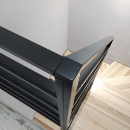 bertaweld - Nowoczesna, czarna, metalowa balustrada schodowa z poziomymi prętami, widok z góry na drewniane stopnie w jasnym odcieniu.