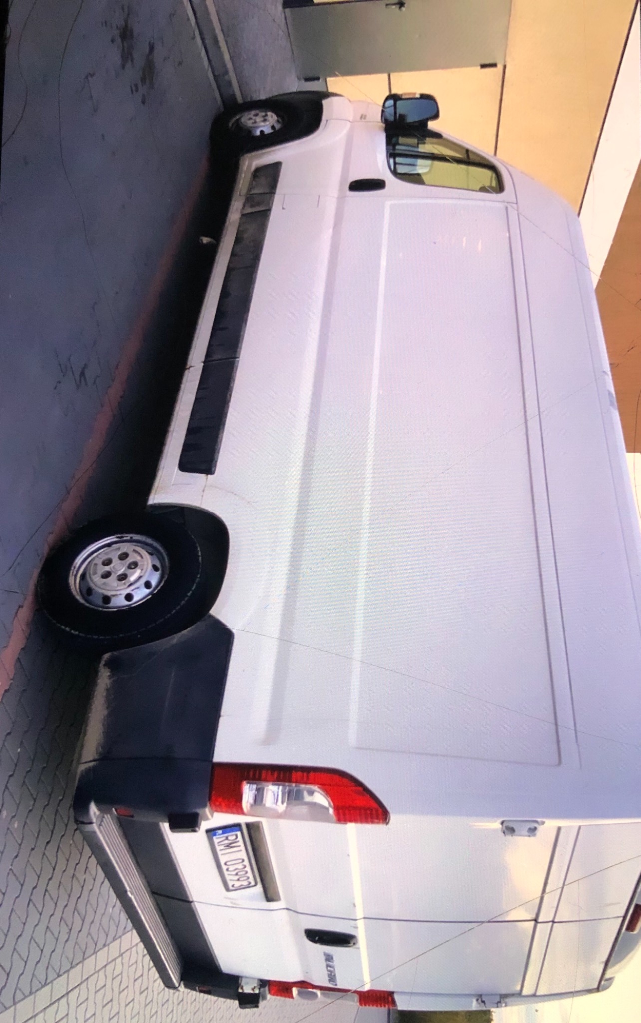 Biały samochód dostawczy typu furgon, widok z boku i tyłu, zaparkowany na kostce brukowej, z widoczną tablicą rejestracyjną RMI 03993.