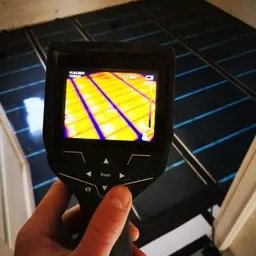 Samurio sp. z o.o. - Pomiar temperatury maty grzewczej termowizją; widok z kamery termowizyjnej na rozłożoną matę na podłodze w trakcie montażu.