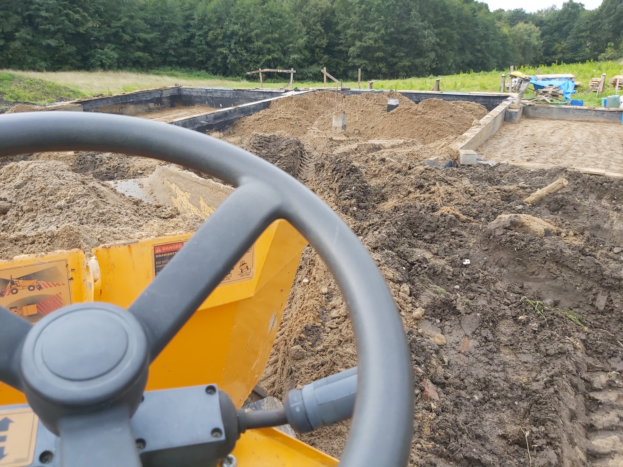 Wypełnianie fundamentów piaskiem zasypowym przy pomocy koparko ładowarki oraz wozidła obrotowego ładowność 3 tony