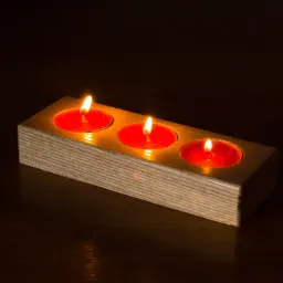 Drewniany świecznik na trzy czerwone tealighty, płomienie świec oświetlają ciemne otoczenie.