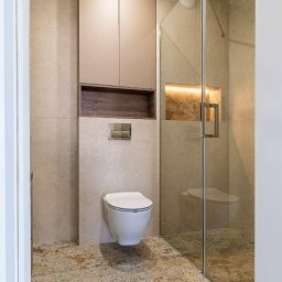 Fado Wood - Nowoczesna łazienka z szafką na wymiar w Łodzi. Beżowe płytki, podświetlana wnęka i szklana kabina prysznicowa tworzą spójną całość.