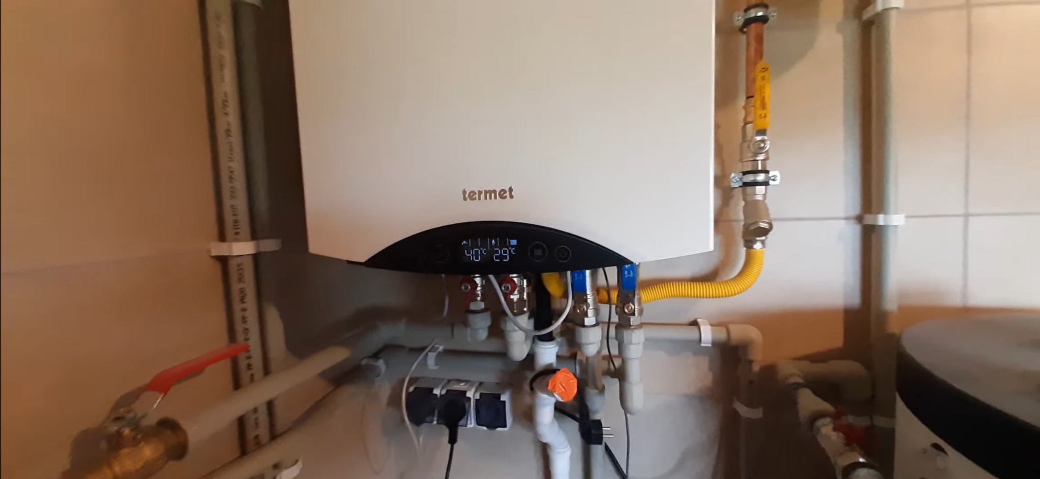 Zamontowany piec gazowy Termet w kotłowni w Szklarskiej Porębie. Widoczne rury, zawory i podłączenia. Na wyświetlaczu temperatura 40 stopni Celsjusza.