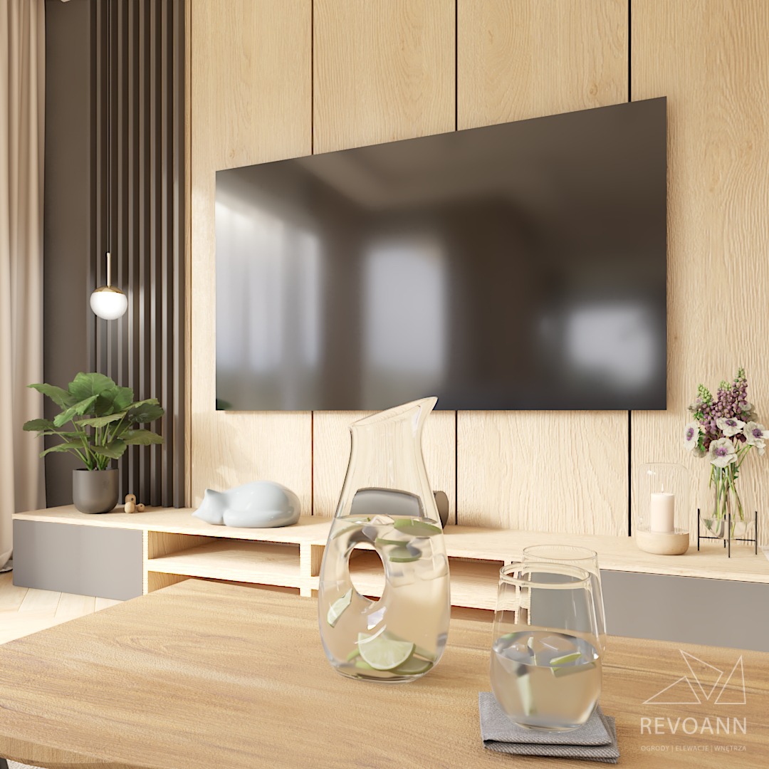 Jasne, nowoczesne wnętrze salonu z drewnianą ścianą, dużym telewizorem, rośliną w doniczce, ceramiczną figurką śpiącego kota i dzbankiem z wodą i limonką na drewnianym stole. W tle widoczna zasłona...