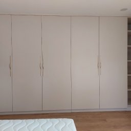 Szafa z drzwiami na zawiasach i automatycznym oświetleniem wewnątrz.