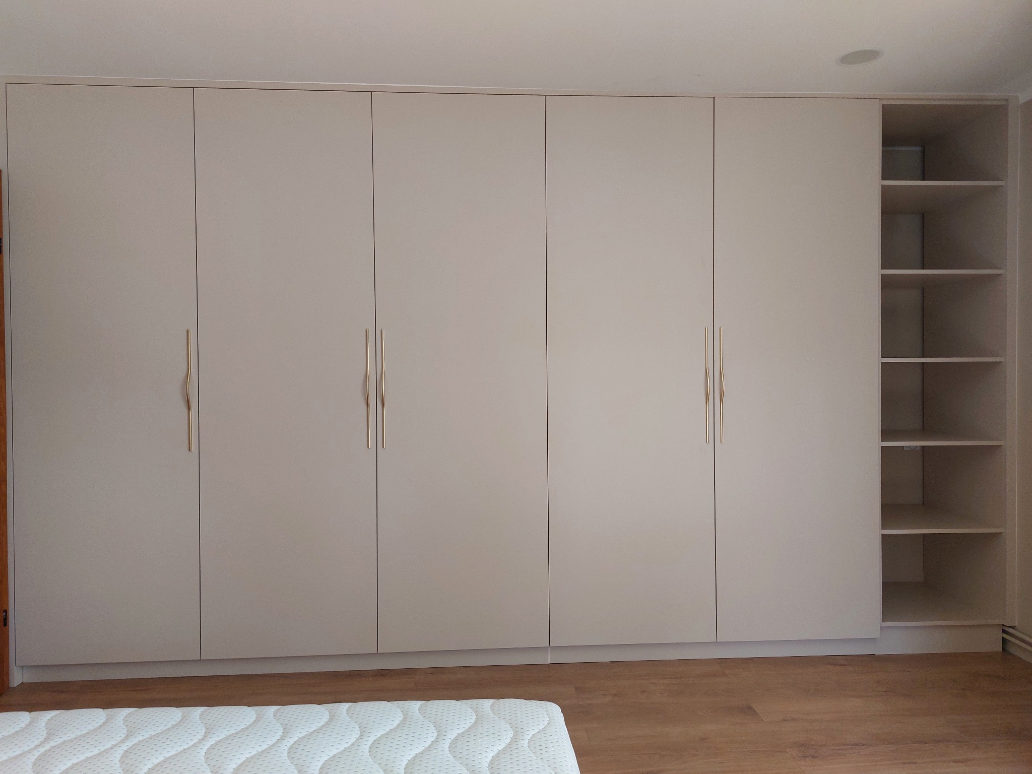 Szafa z drzwiami na zawiasach i automatycznym oświetleniem wewnątrz.