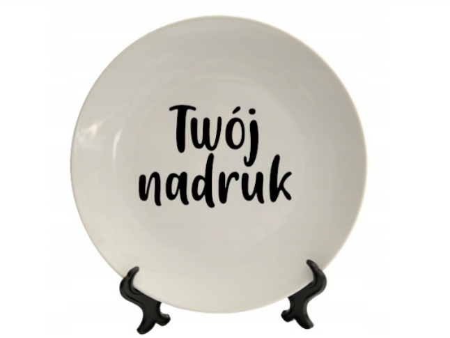 Biały talerz z czarnym napisem 'Twój nadruk' umieszczony na czarnym, plastikowym stojaku.