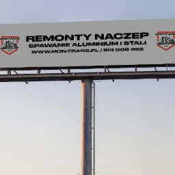 Billboard reklamujący remonty naczep, spawanie aluminium i stali, z logo firmy Montrans po bokach i adresem strony internetowej.