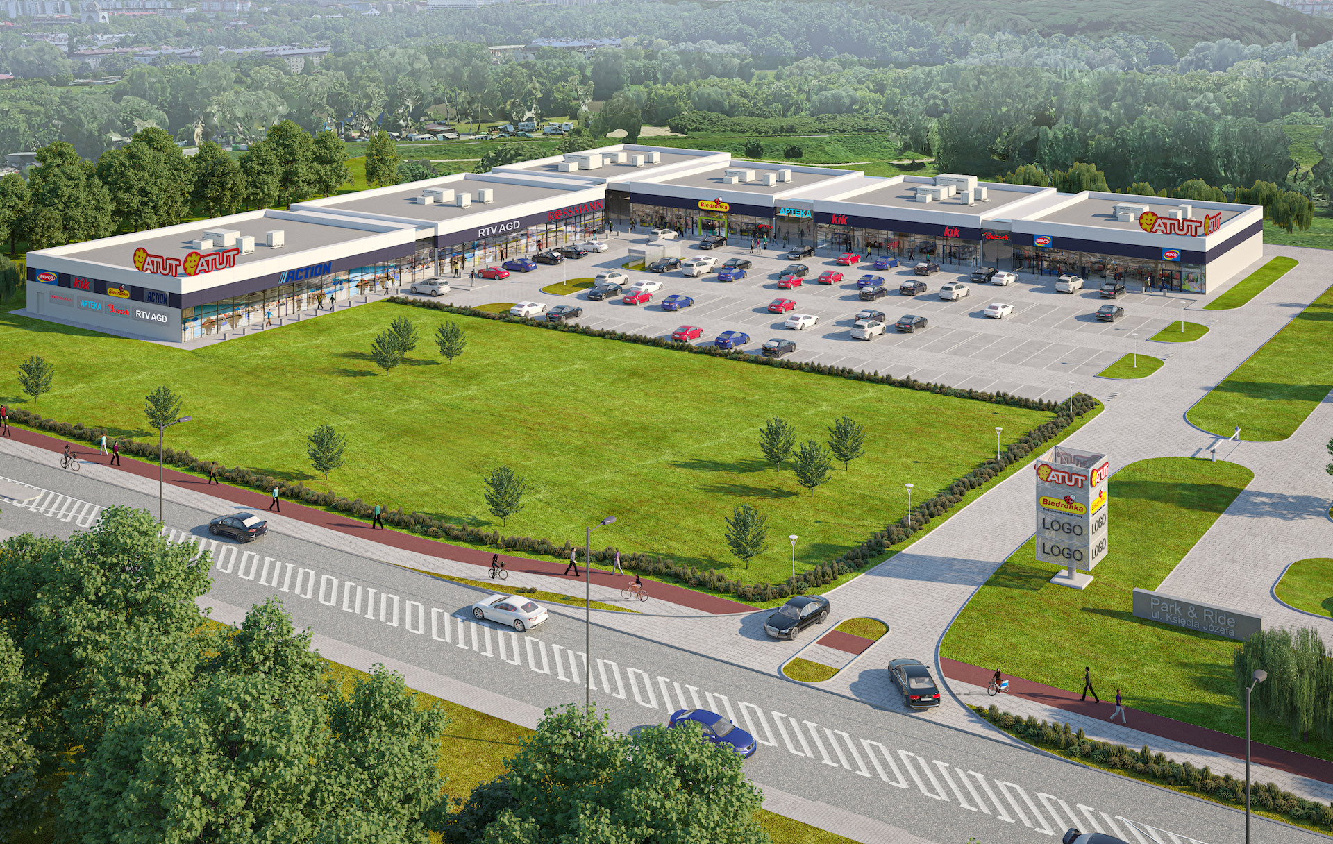 Wizualizacja z lotu ptaka centrum handlowego z parkingiem, zielonym terenem, chodnikami i jezdnią, prezentująca architekturę budynku i zagospodarowanie przestrzeni.