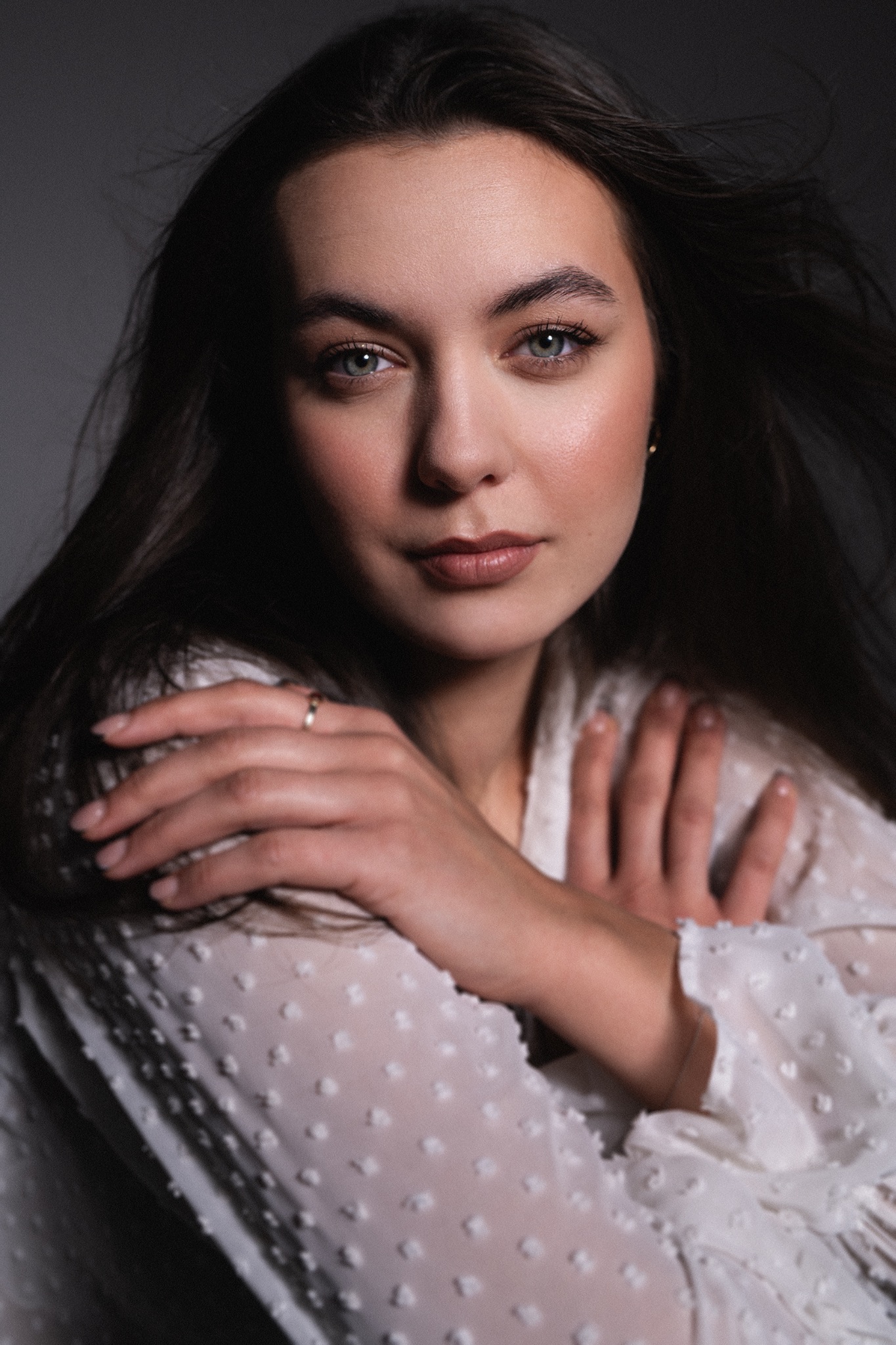 Portret kobiety z delikatnym makijażem, podkreślającym naturalne piękno. Uwagę przyciągają zielone oczy i subtelnie podkreślone usta, tworząc elegancki i świeży wygląd.