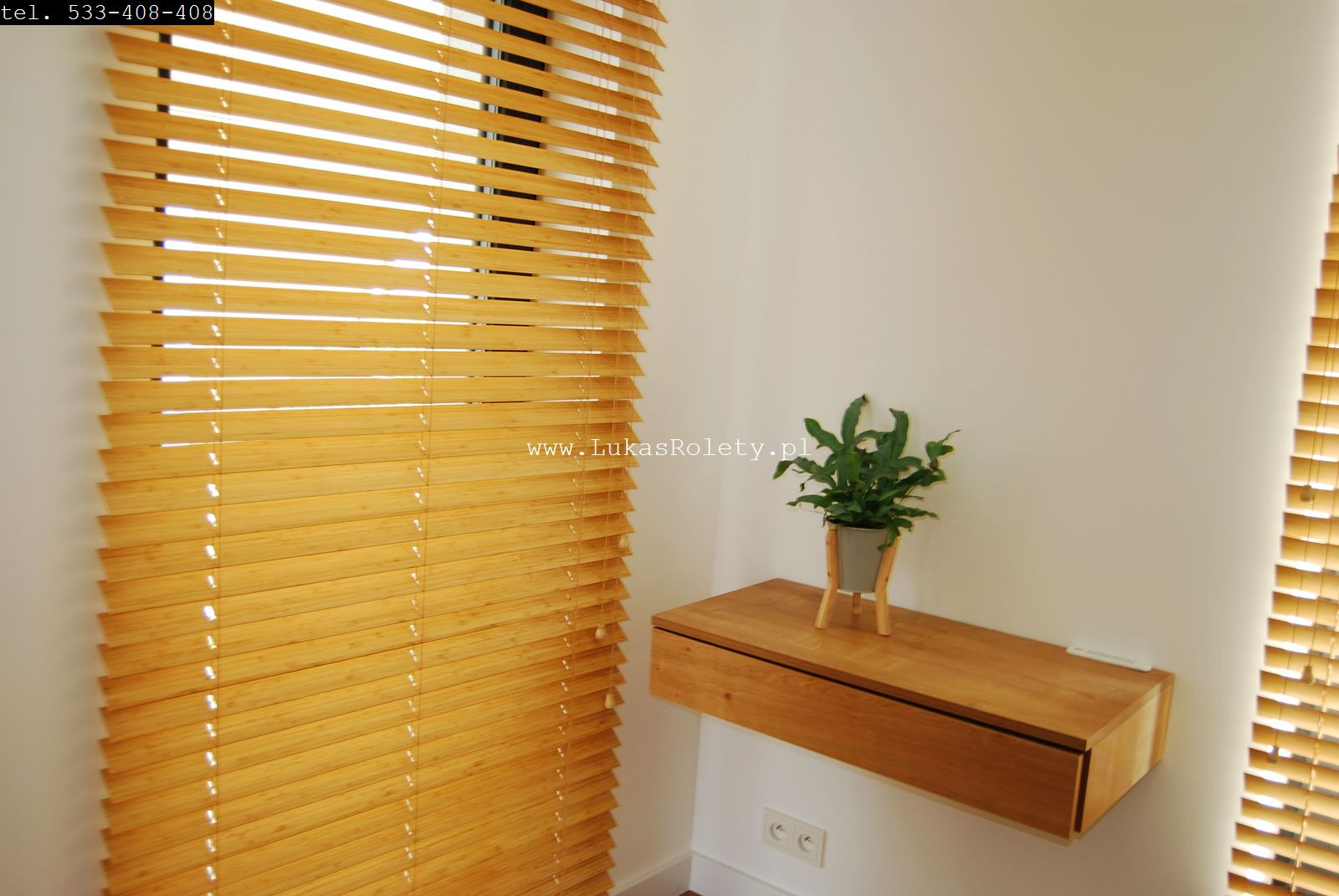 Jasne drewniane żaluzje poziome w minimalistycznym wnętrzu, obok drewniana półka z rośliną doniczkową.