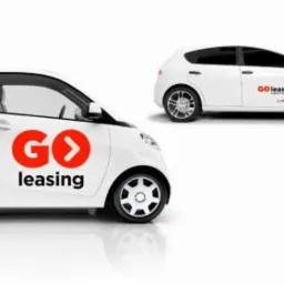 Dwa białe samochody osobowe z logo firmy leasingowej na drzwiach, ustawione na białym tle z odbiciem.