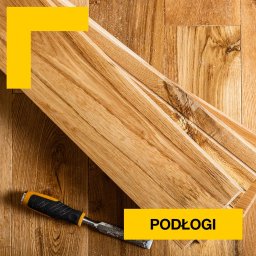 Piotr Szczepanek - Układanie drewnianej podłogi w Warszawie: deski parkietowe z widocznym uszkodzeniem i dłuto z czarno-żółtą rękojeścią na tle gotowej podłogi.