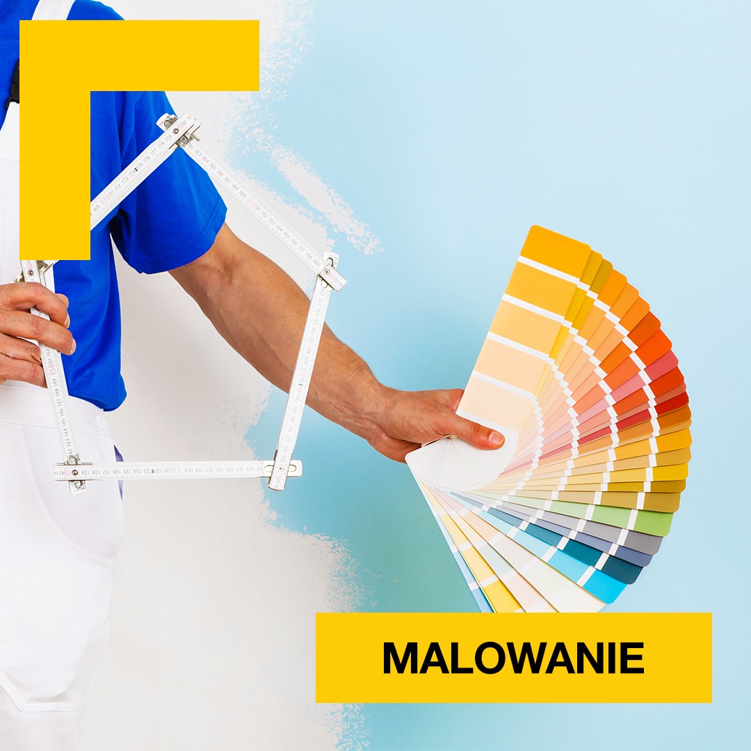 Malarz w białym kombinezonie prezentuje wachlarz kolorów farb na tle świeżo pomalowanej, błękitnej ściany, trzymając w drugiej ręce składaną miarkę.