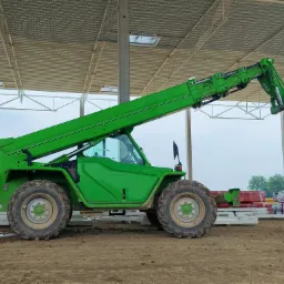 Ładowarka teleskopowa Merlo wyposażona w hak i zawiesia łańcuchowe. Usługa wynajmu z operatorem wykonana w Mszczonowie.