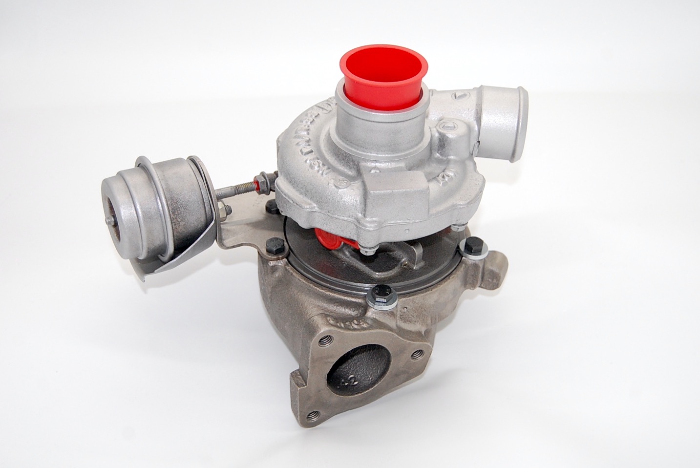 Turbosprężarka samochodowa, widok z góry, z czerwonym elementem wlotowym, na białym tle.