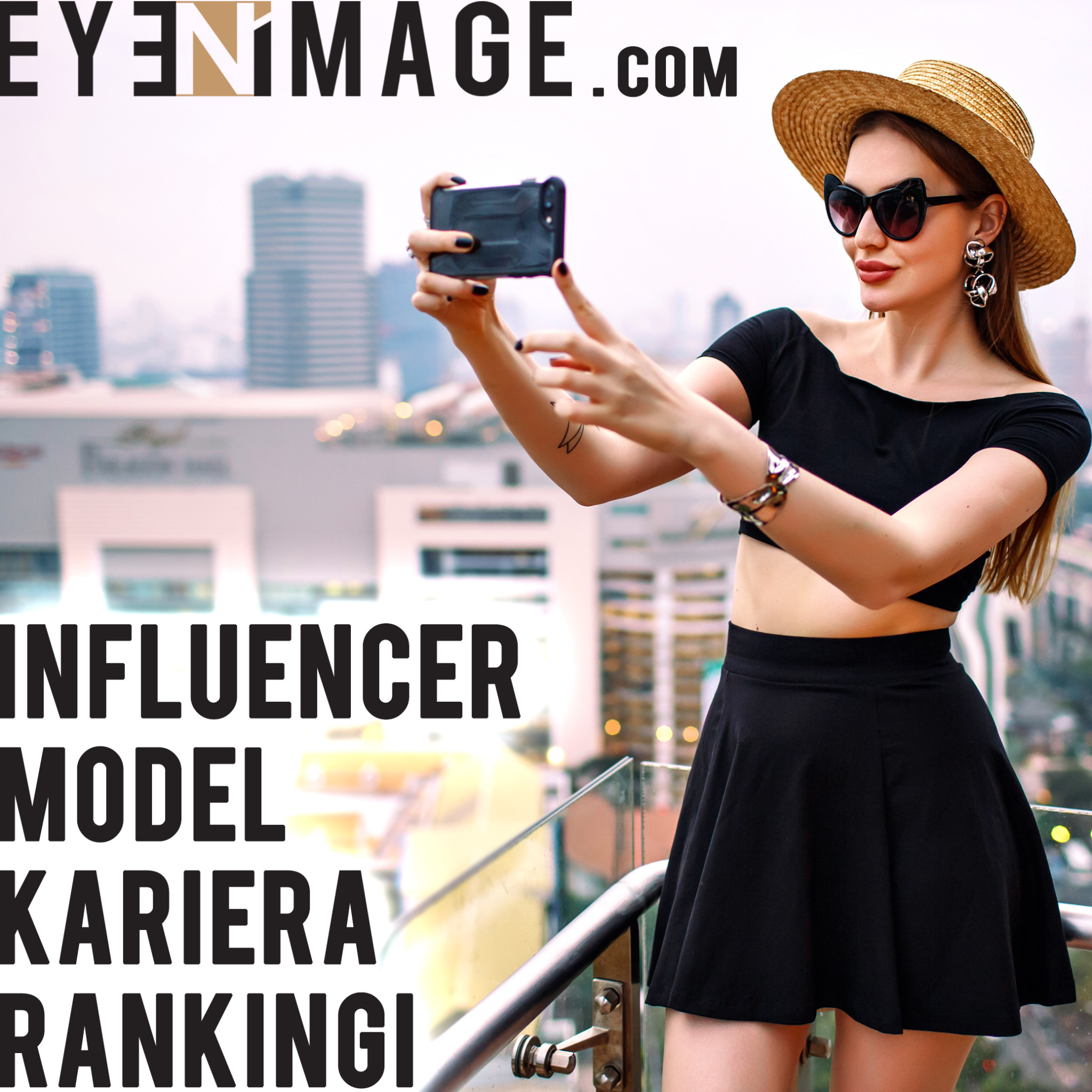 Kobieta w kapeluszu i okularach w kocich oprawkach robi selfie na tle miejskiego krajobrazu, widoczne kolczyki w kształcie kwiatów i tatuaż na ramieniu.