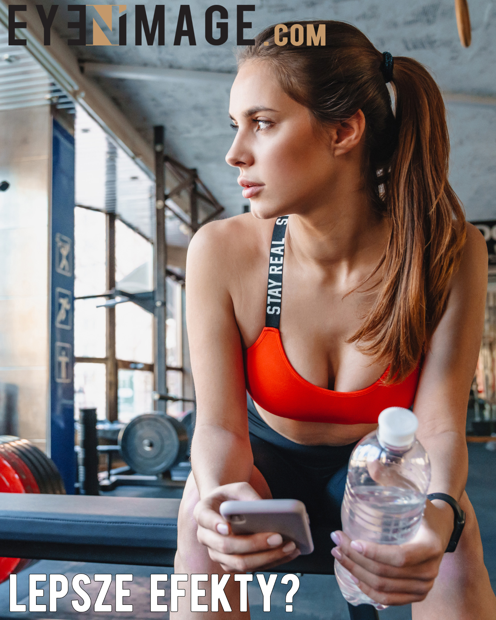 Kobieta w sportowym stroju siedzi na ławce w siłowni, trzymając telefon i butelkę wody, zamyślona patrzy w lewo.