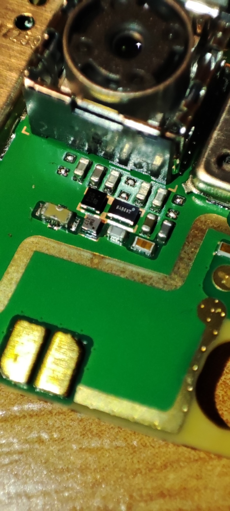 Zbliżenie na fragment zielonej płytki drukowanej z widocznymi elementami elektronicznymi, takimi jak kondensatory i układy scalone, z numerem seryjnym 2A9237 na jednym z nich, sfotografowane...