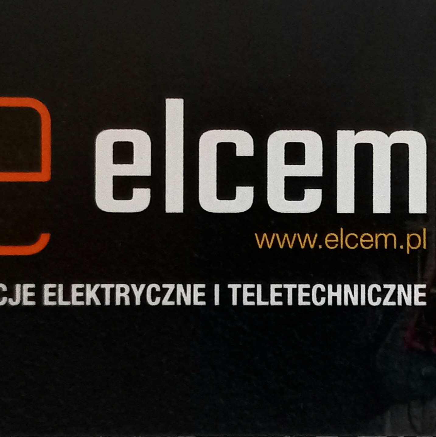 Logo firmy Elcem z pomarańczowym elementem graficznym, białą nazwą i złotym adresem strony internetowej, pod spodem napis 'Usługi elektryczne i teletechniczne' na czarnym tle.