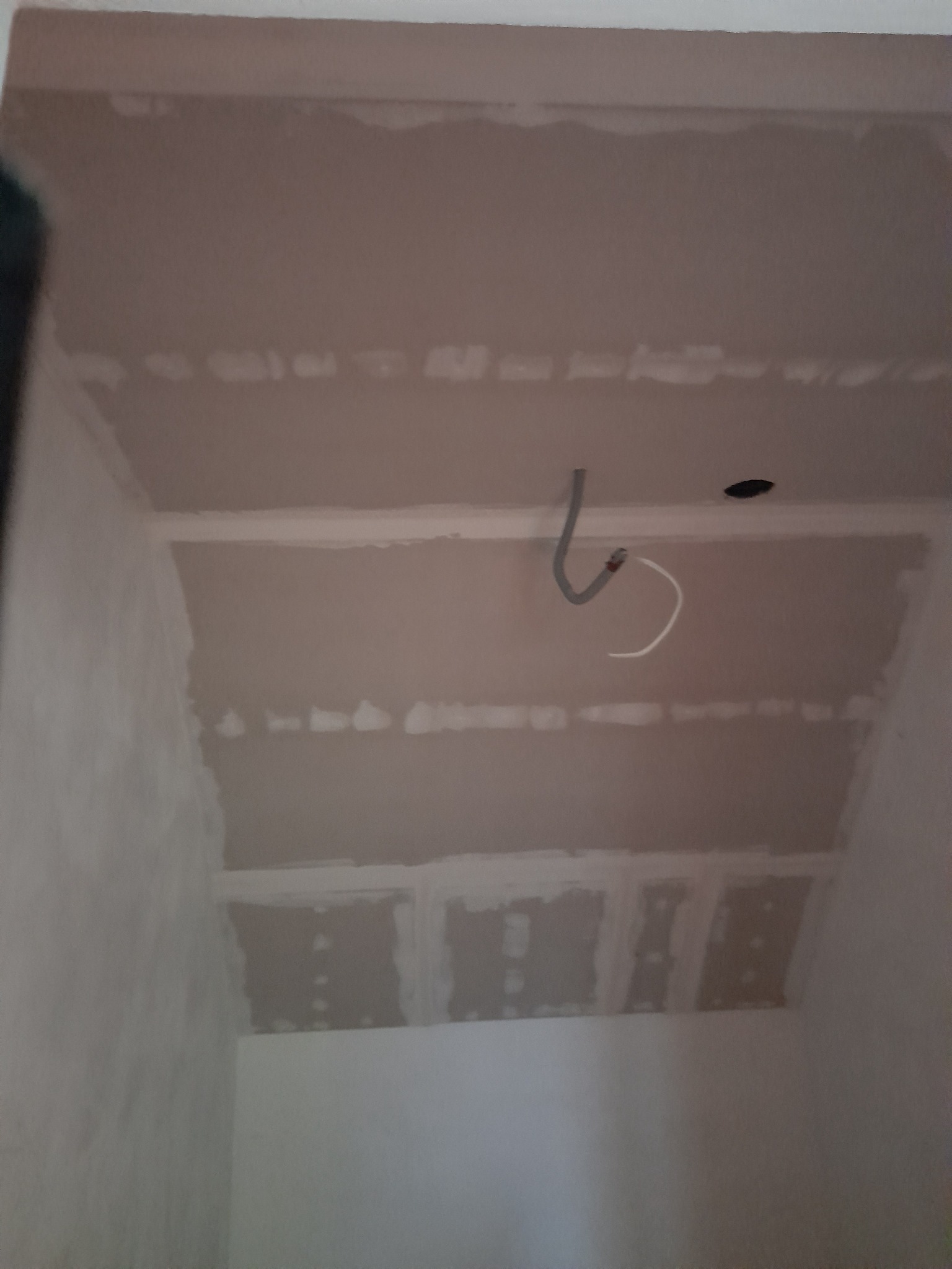 Sufit z płyt kartonowo-gipsowych w trakcie montażu, widoczne łączenia płyt i przewody elektryczne.