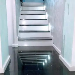 Białe schody z czarnymi akcentami i błyszczącą podłogą, widok z dołu, oświetlenie punktowe