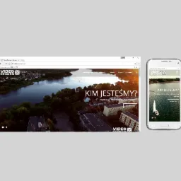 Wyświetlona strona internetowa Video Dronem na monitorze komputera i smartfonie, prezentująca widok z drona na jezioro i zabudowania miejskie, z napisem 'Kim jesteśmy?' i przyciskiem 'Sprawdź nas'.