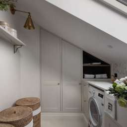 EMITOM design & build S.C. - Poddasze zaadaptowane na pralnię z zabudową szaf pod skosem, pralką Electrolux, marmurowym blatem, dekoracyjną mozaiką na ścianie, wiklinowymi koszami na pranie i oknem dachowym