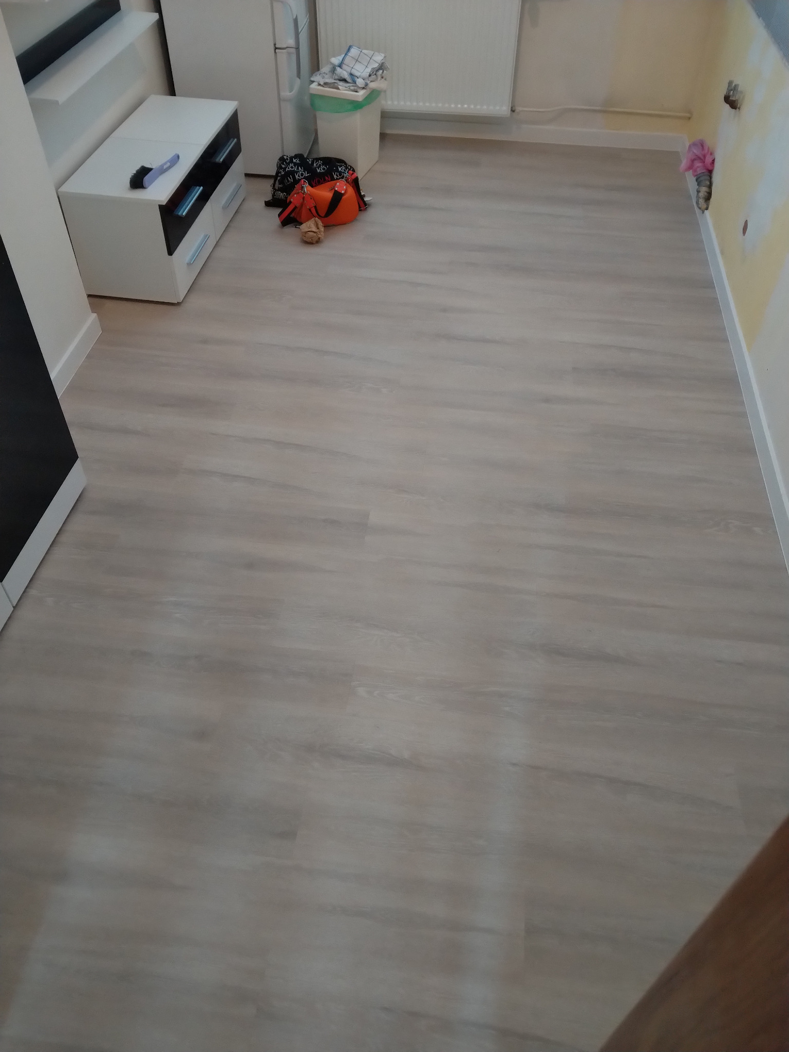 Zamontowane panele winylowe na klik Luxor MS 002 w jasnym odcieniu drewna, widok na całą podłogę w pomieszczeniu z meblami i akcesoriami.