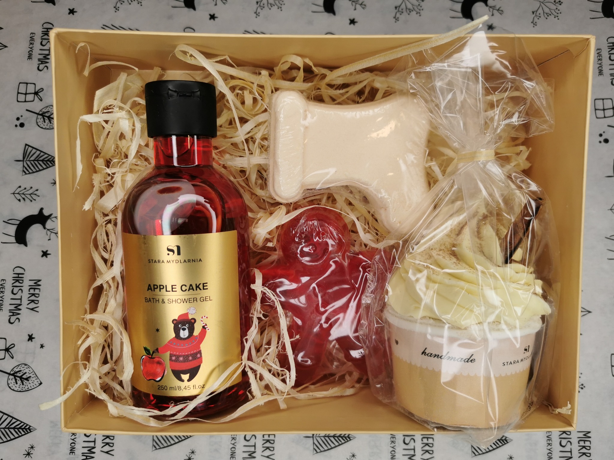 Zestaw kosmetyków Stara Mydlarnia Apple Cake w beżowym pudełku wypełnionym siankiem: żel do kąpieli i pod prysznic, mydło w kształcie buta, mydło w kształcie ludzika i mydło w formie babeczki...