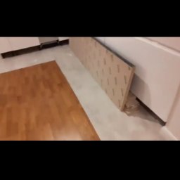 Kosmiczne Remonty - Przygotowanie do montażu płyty karton gips na ścianie w pomieszczeniu z drewnianą podłogą, widoczna płyta oparta o ścianę.