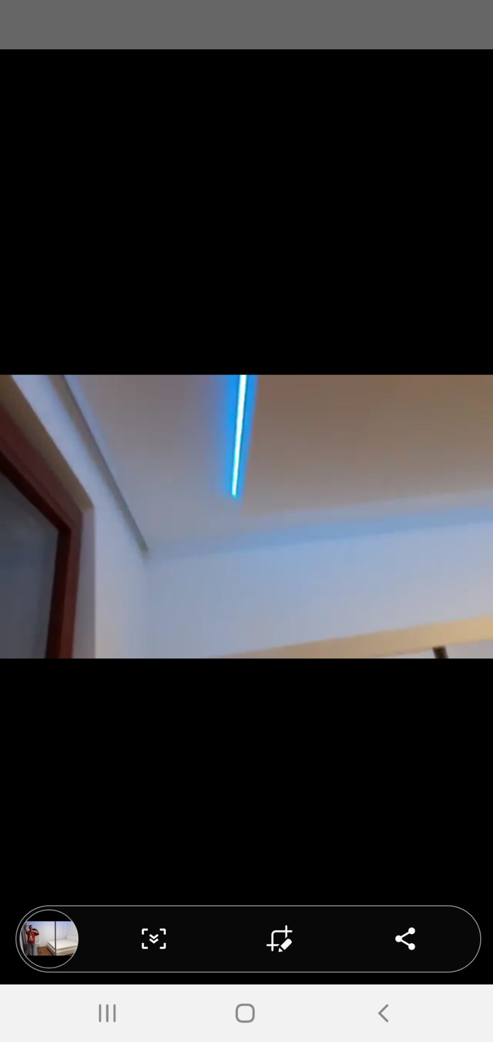 Nowoczesne oświetlenie LED wpuszczone w sufit podwieszany, widoczne fragmenty ściany i futryny drzwi.