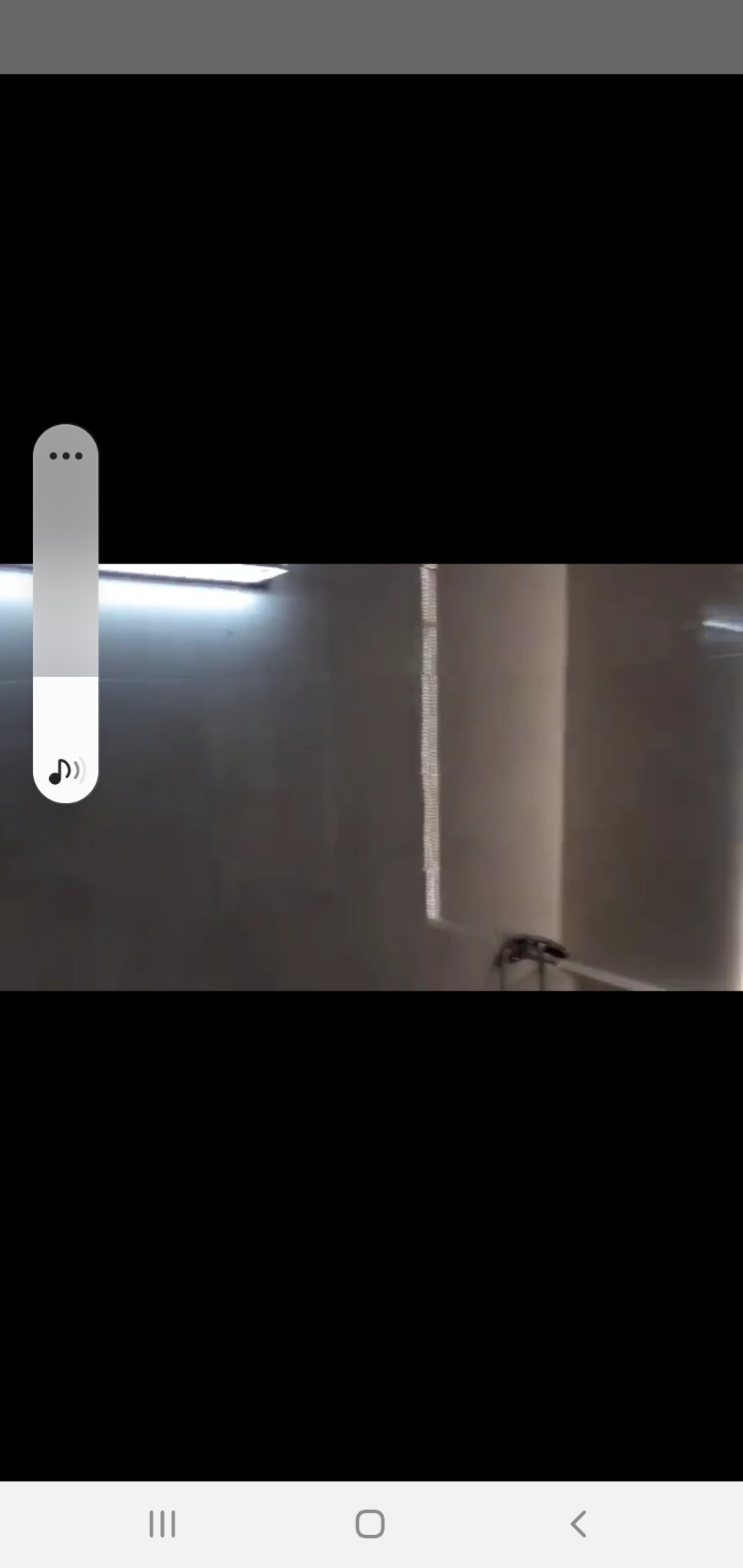 Ściana w trakcie prac wykończeniowych, widoczny sprzęt do natryskowego nakładania gładzi, oświetlenie sufitowe.