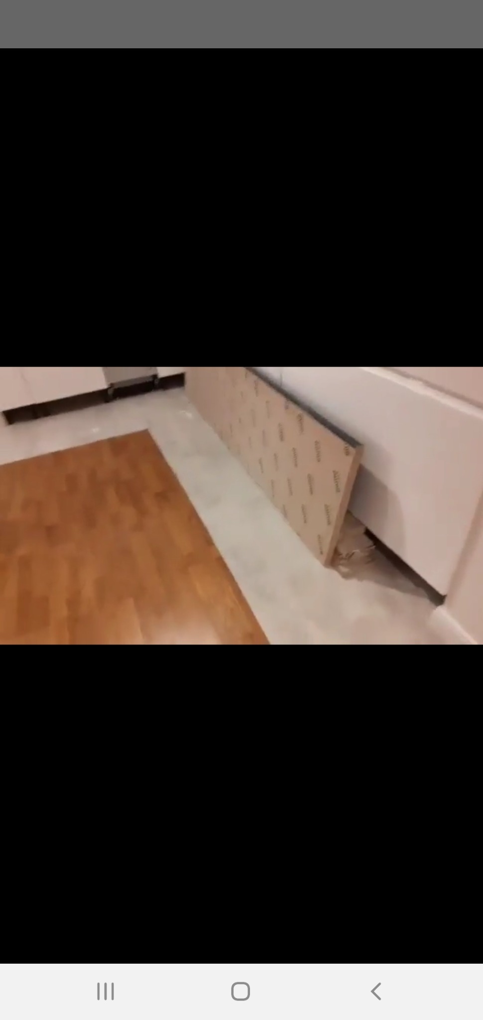 Przygotowanie do montażu płyty karton gips na ścianie w pomieszczeniu z drewnianą podłogą, widoczna płyta oparta o ścianę.