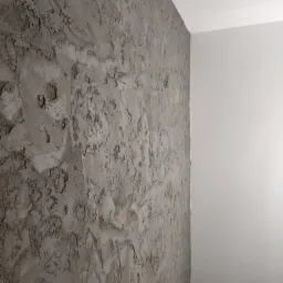 Świeżo nałożona, surowa gładź szpachlowa o grubej fakturze na ścianie w Zgorzelcu, widok na róg pomieszczenia z kontrastem gładkiej, pomalowanej ściany.