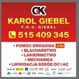 Czerwono-biała reklama firmy Karol Giebel F.H.U. Giebel oferującej pomoc drogową 24h, blacharstwo, lakiernictwo, mechanikę i likwidację szkód OC i AC z numerem telefonu 515 409 345 oraz logotypem...