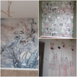 Sławomir Jurga - Trzy różne tapety na ścianach: abstrakcyjne kwiaty w odcieniach szarości i błękitu, dziecięca tapeta z motywem gór, zwierząt i domków, oraz rysunek miasta z postaciami superbohaterek.