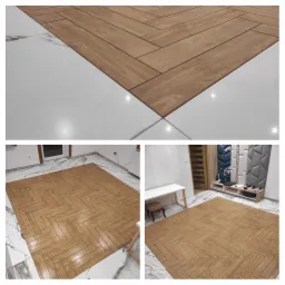 Ułożona podłoga z płytek imitujących drewno w jodełkę, otoczona białymi płytkami na podłodze w pomieszczeniu z białymi ścianami i meblami.