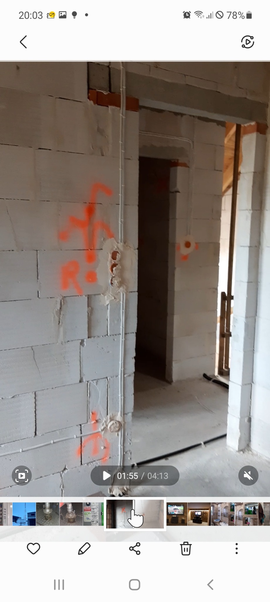 Ściana z betonu komórkowego w trakcie prac, widoczne przewody elektryczne, puszki pod gniazdka i oznaczenia pomarańczowym sprayem.