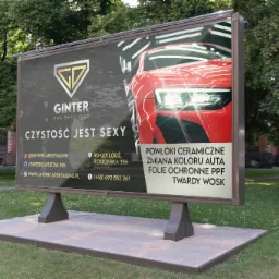 Wolnostojący billboard reklamowy firmy Ginter Car Detailing z hasłem 'Czystość jest sexy', prezentujący usługi powłok ceramicznych, zmiany koloru auta, folii ochronnych PPF i twardego wosku...