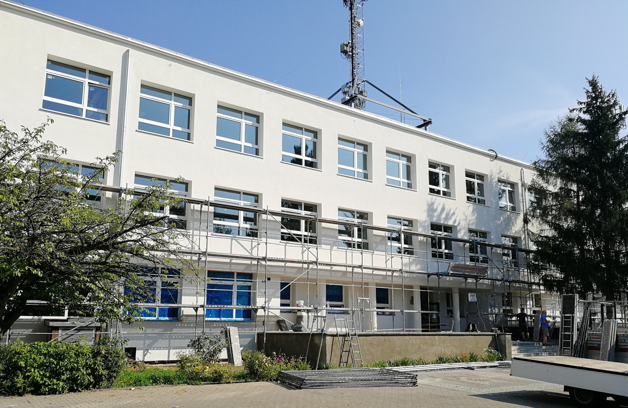 Budynek w Gorzowie Wielkopolskim z nowymi oknami, zabezpieczonymi folią i otoczony rusztowaniem, widoczne prace montażowe.