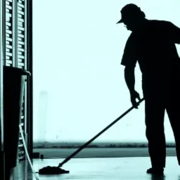 Silhouetted janitor with cap mopping a shiny office floor in a long, narrow hallway with rows of dark cabinets.