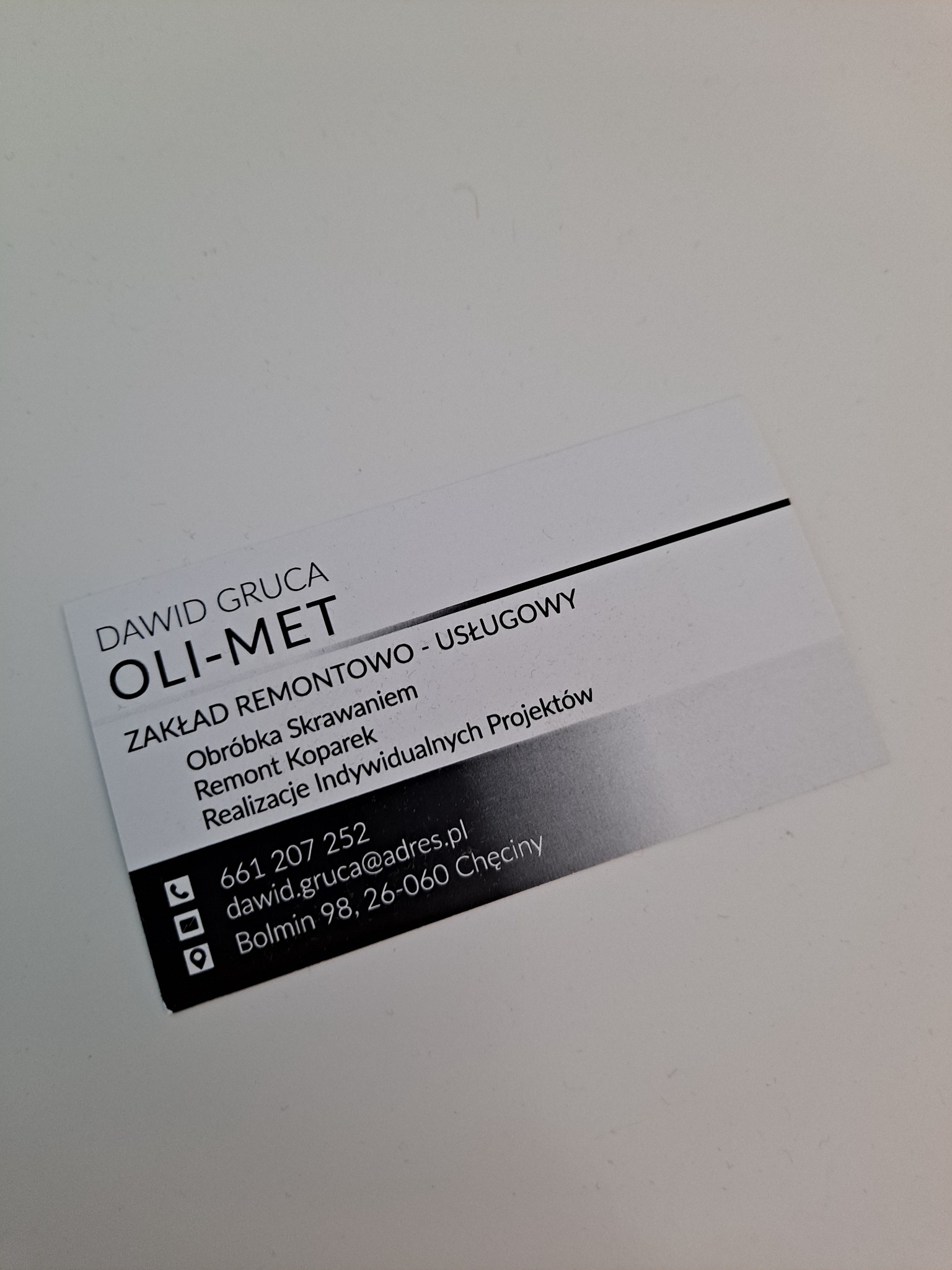 Wizytówka firmy OLI-MET Dawid Gruca oferującej obróbkę skrawaniem, remont koparek i realizację indywidualnych projektów, z danymi kontaktowymi.