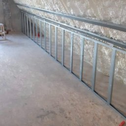 Kistela Usługi Budowlane - Poddasze z izolacją piankową i metalową konstrukcją szkieletową, przygotowane do dalszych prac wykończeniowych.