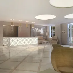 Jasne, przestronne lobby z recepcją oświetloną od dołu, dekoracyjnymi drzwiami i wygodnymi fotelami w neutralnych kolorach.