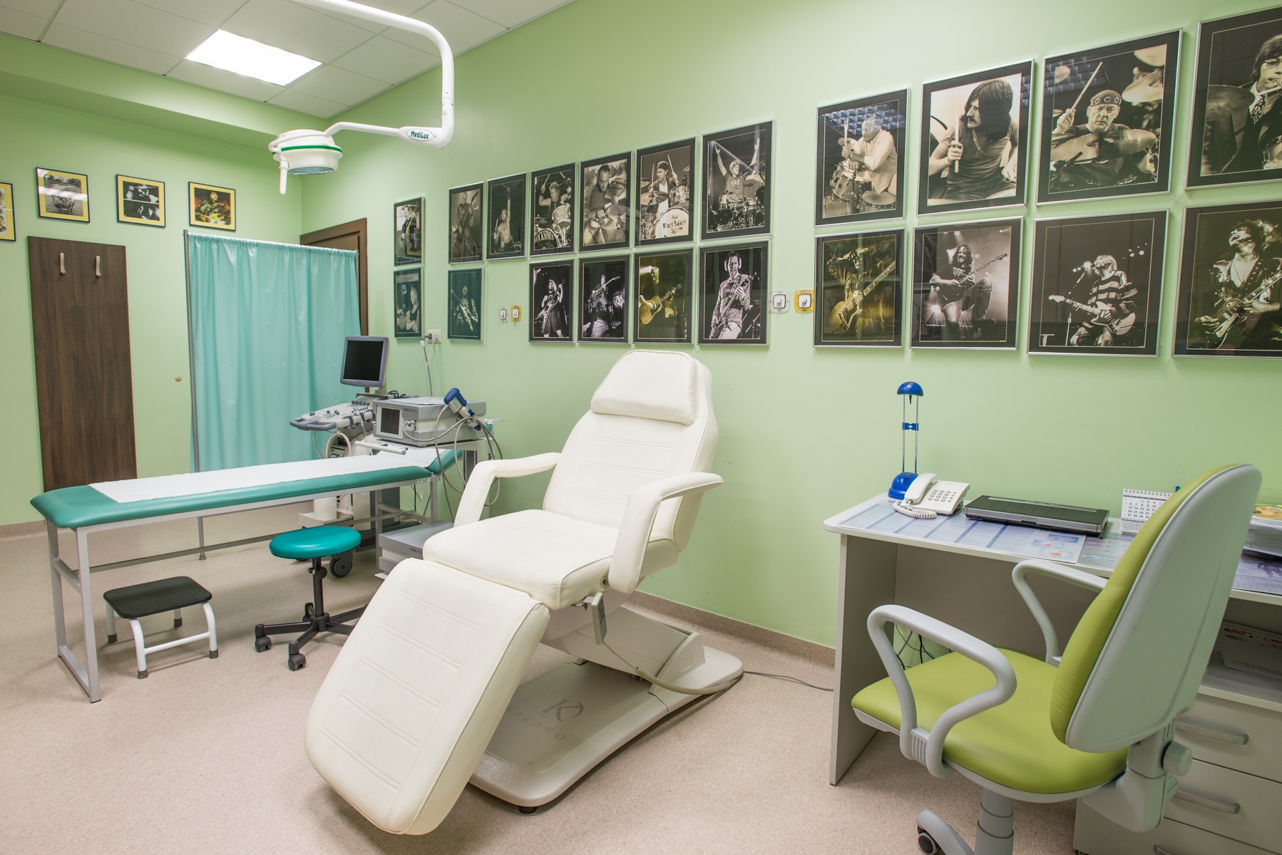 Jasnozielony gabinet lekarski z białym fotelem zabiegowym, aparaturą USG i czarno-białymi zdjęciami muzyków rockowych na ścianie.