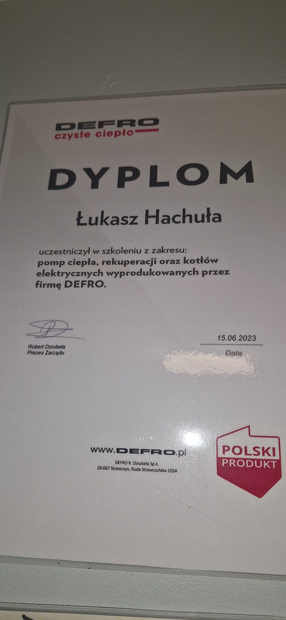 Dyplom ukończenia szkolenia firmy DEFRO dla Łukasza Hachuły w zakresie pomp ciepła, rekuperacji i kotłów elektrycznych, z datą 15.06.2023 i podpisem Prezesa Zarządu Roberta Dziubeły.