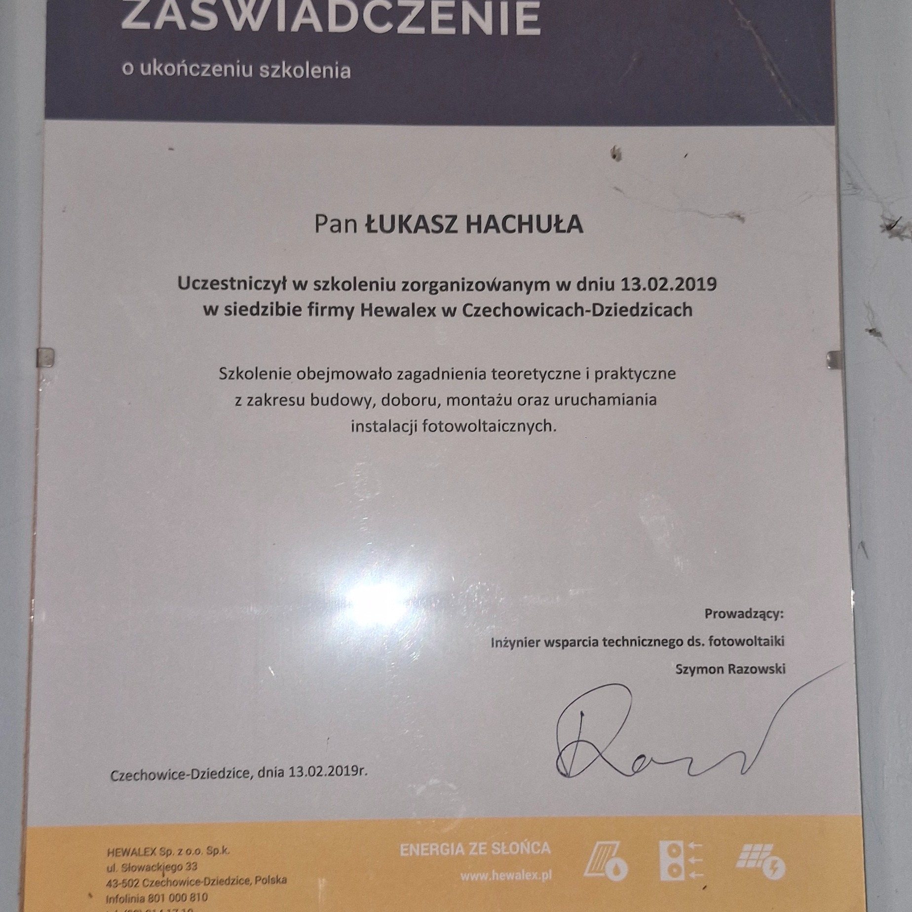 Skan zaświadczenia o ukończeniu szkolenia z zakresu budowy, doboru, montażu i uruchamiania instalacji fotowoltaicznych, wystawionego przez firmę Hewalex dla Pana Łukasza Hachuły, z podpisem Szymona...
