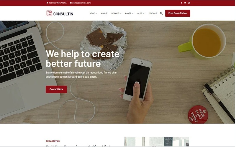 Laptop, smartfon dotykany palcem, czekolada w folii, notatnik z długopisem i kubek z napojem na drewnianym biurku, prezentujące treść strony internetowej z hasłem 'We help to create better future'.