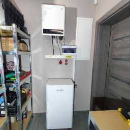 MelSol Mariusz Setlak - Kompletna instalacja fotowoltaiczna w pomieszczeniu: inwerter GoodWe, bateria Dyness, rozdzielnica. Widoczny regał z narzędziami.
